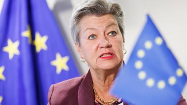 Ylva Johansson vid en EU-flagga