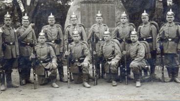 Tyska infanterister 1913 inför första världskriget poserar framför ett monument i Braunschweig som sannolikt har kopplingar till fransk-tyska kriget 1870-71.
